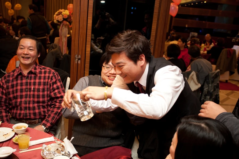 a couple of men sitting at a table with food