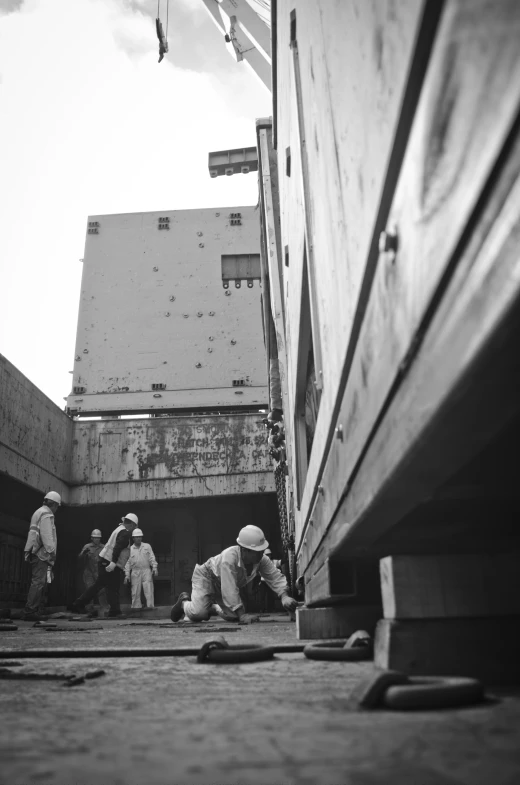 men in construction clothes are working on an area next to a building