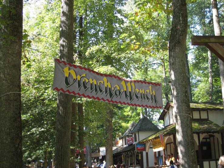 a sign saying a shop is hanging from the trees