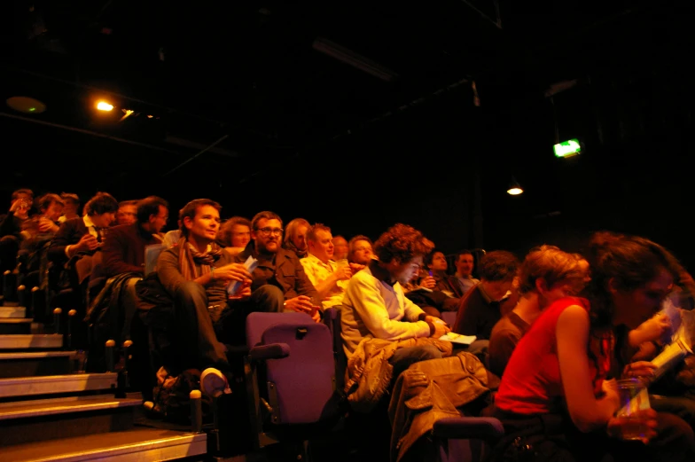 a group of people sitting next to each other in an auditorium