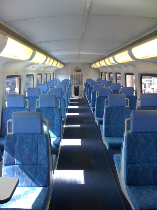 an empty blue train car with blue chairs