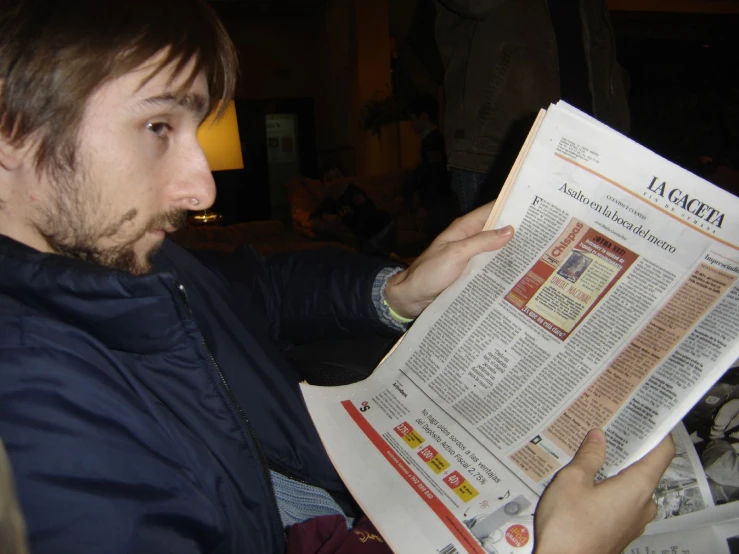 man reading a newspaper while sitting down