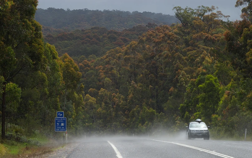 car coming down the road in rain on a cloudy day