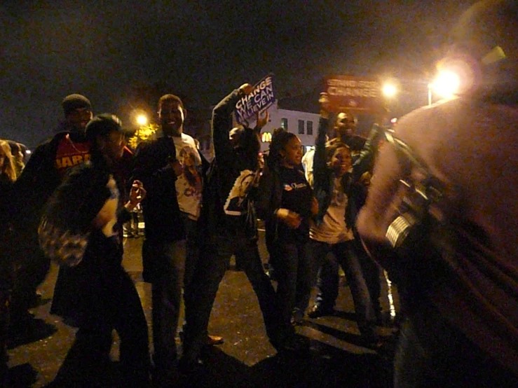 group of protesters in street at night with one person in the background