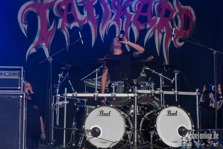 man in all black band playing on a stage