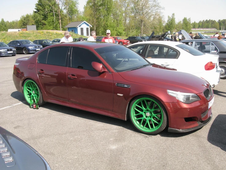 this is a maroon car with bright green wheels