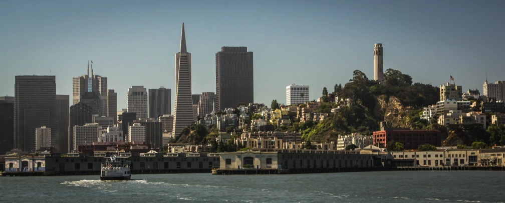 a boat traveling in front of a very tall city