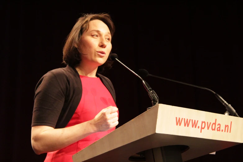 a woman standing at a podium giving a speech