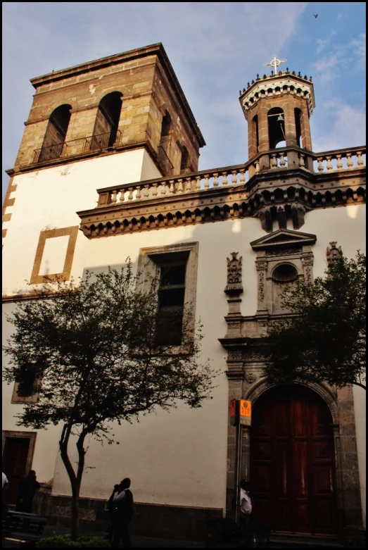 a clock tower and two windows on top of a building