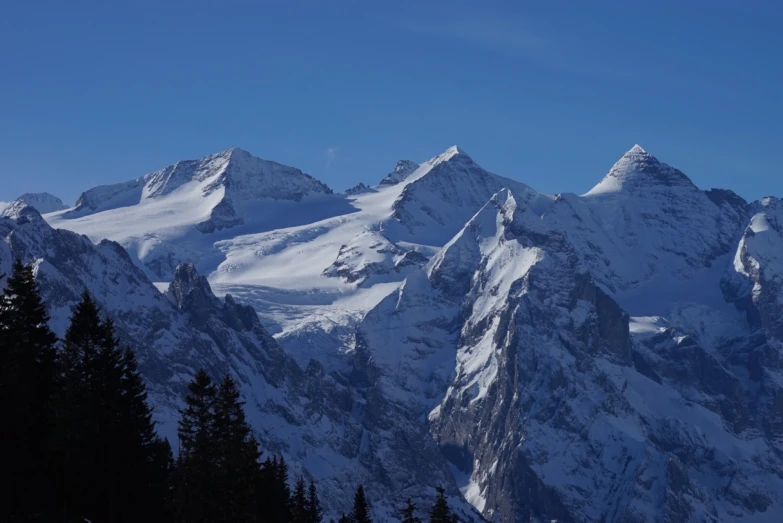 a snow covered mountain covered in a blue sky