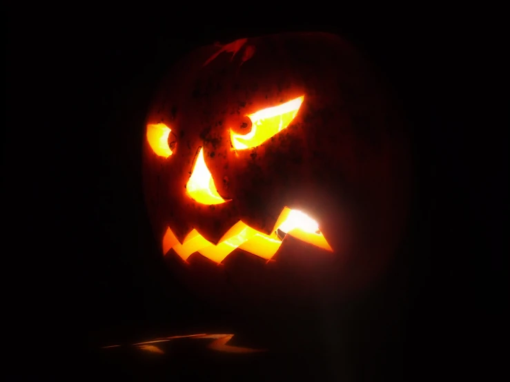 a large pumpkin with two orange eyes lit up