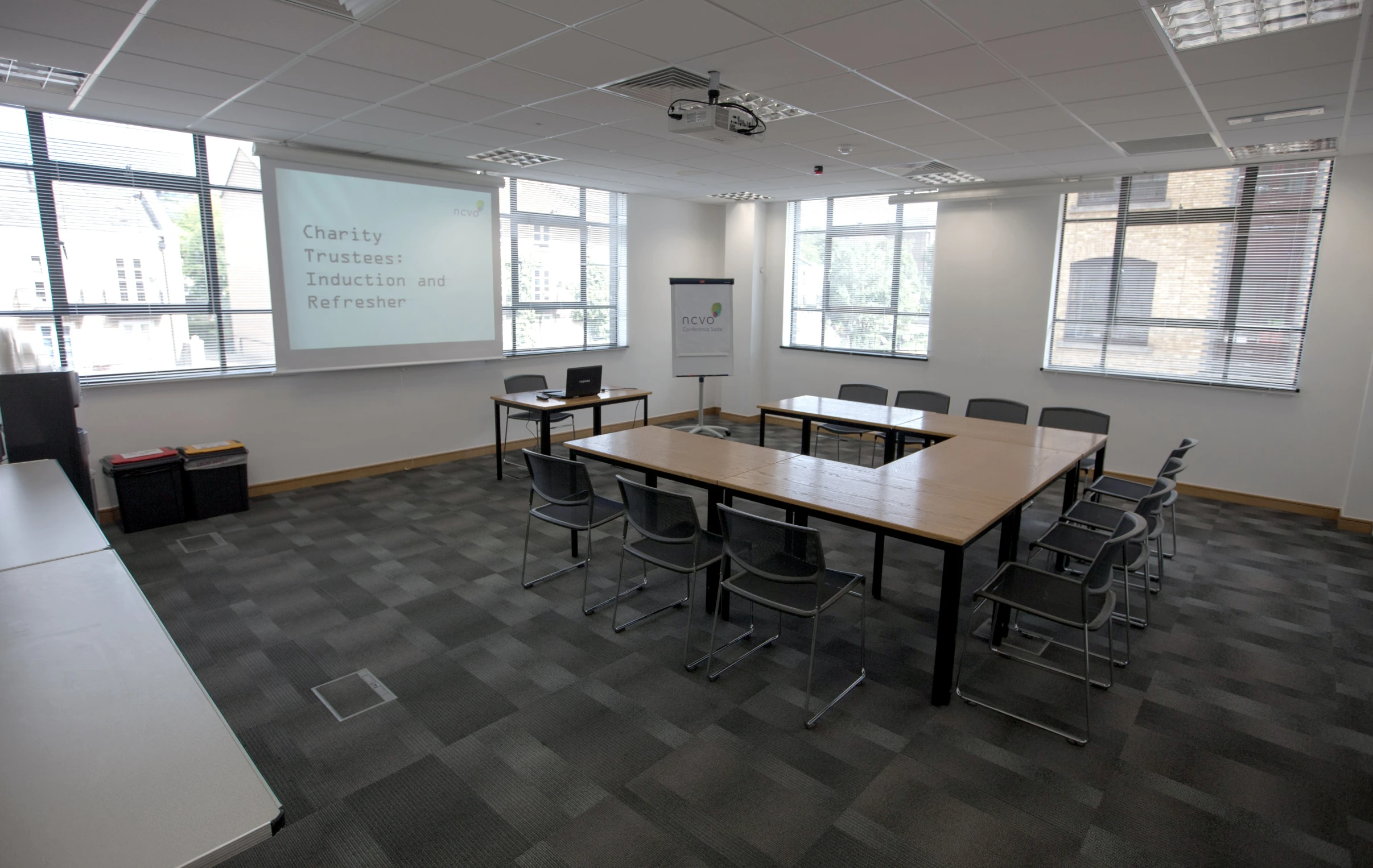 an empty classroom with chairs and a projector screen