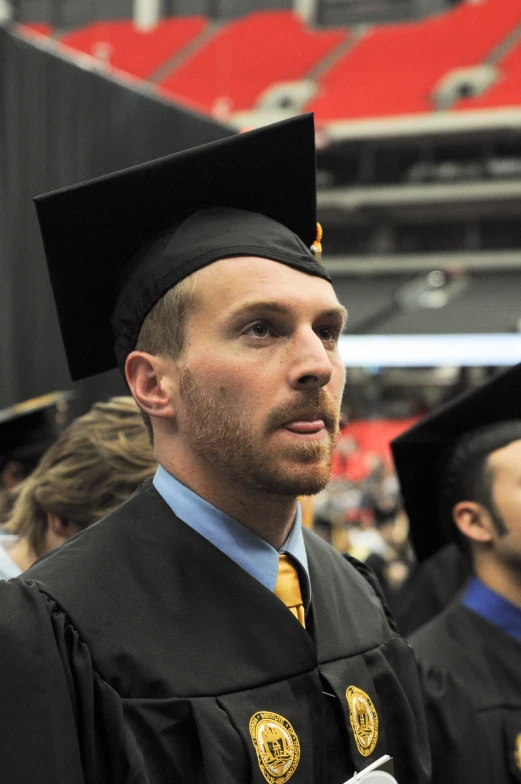 a man wearing a cap and gown standing on a field