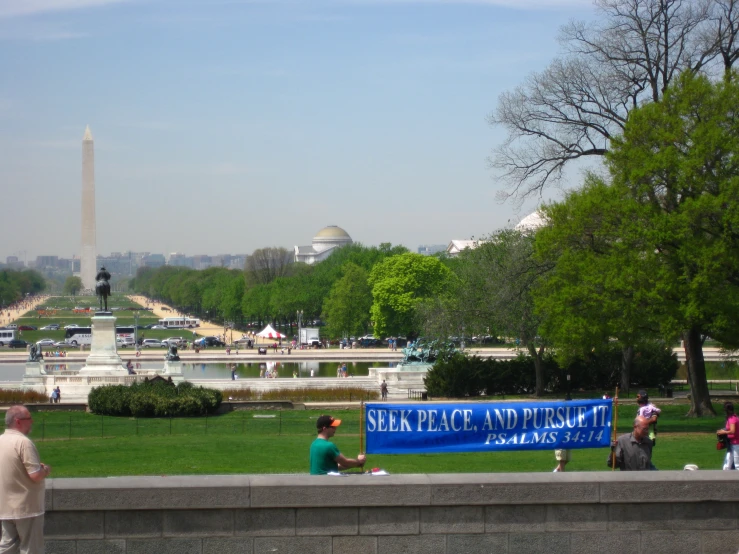 people standing in the background of a field and a view of a monument