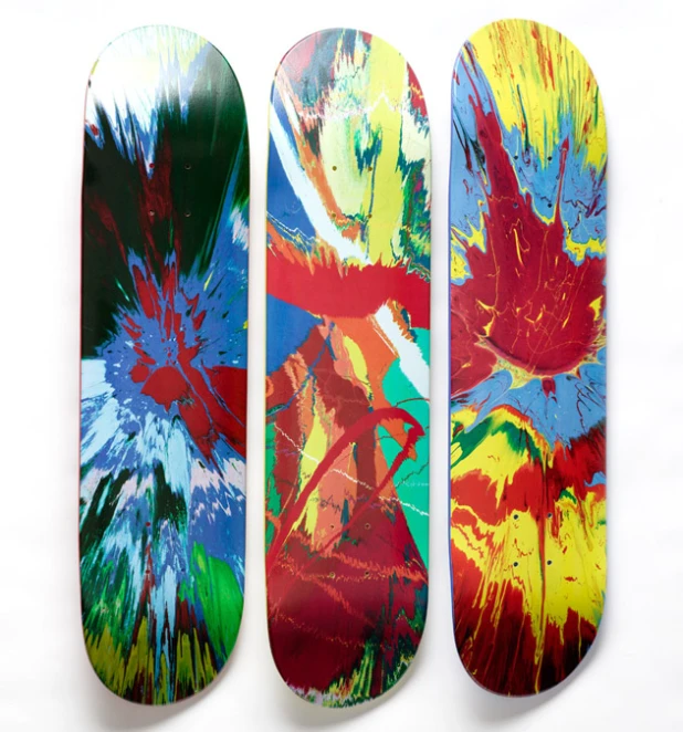 three skateboards sitting on top of each other with different colored paint on them