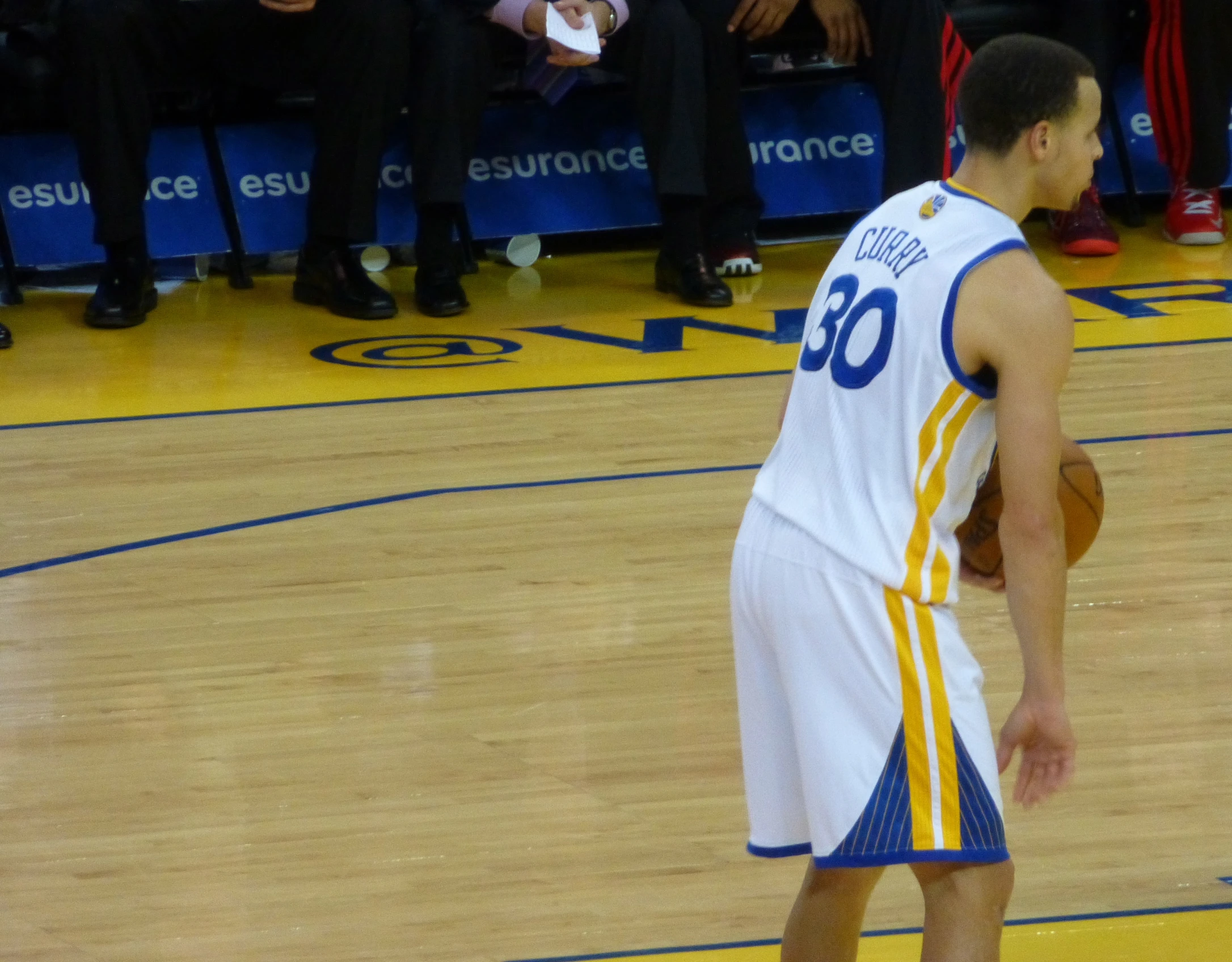 a basketball player standing on the court while holding a ball