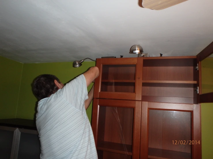 a person putting an air conditioner on a wood bookcase