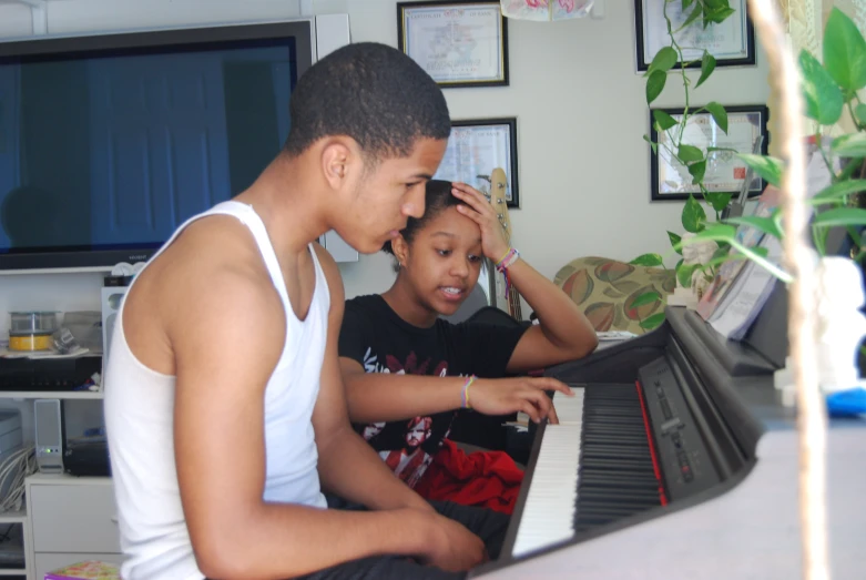 a man and a  are playing a keyboard