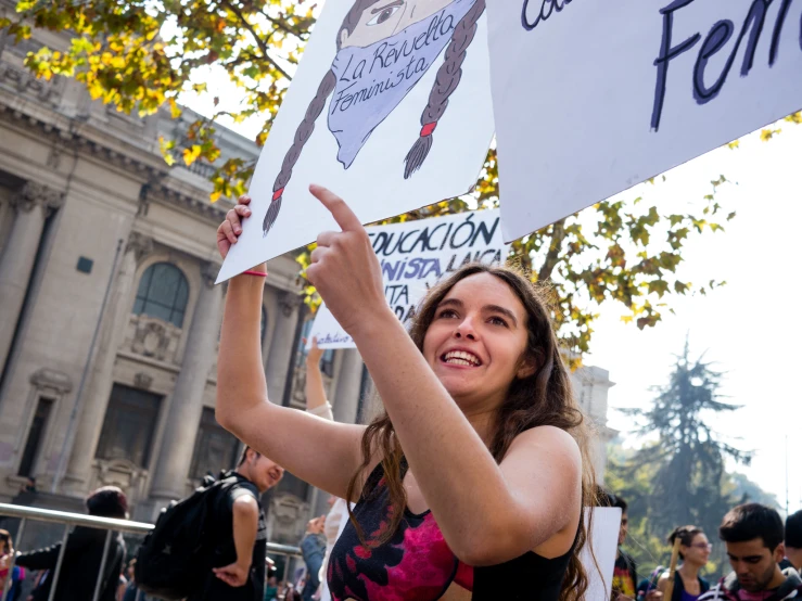 a woman holding a sign that read feminist