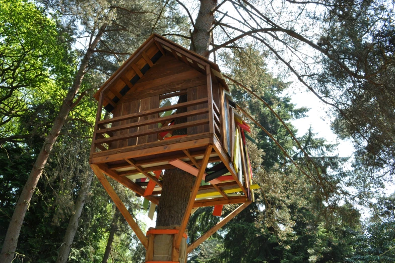 a wooden treehouse on a tree in the woods