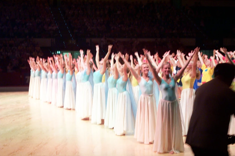 a line of women holding their hands in the air