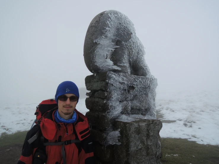 a man stands next to an ice sculpture