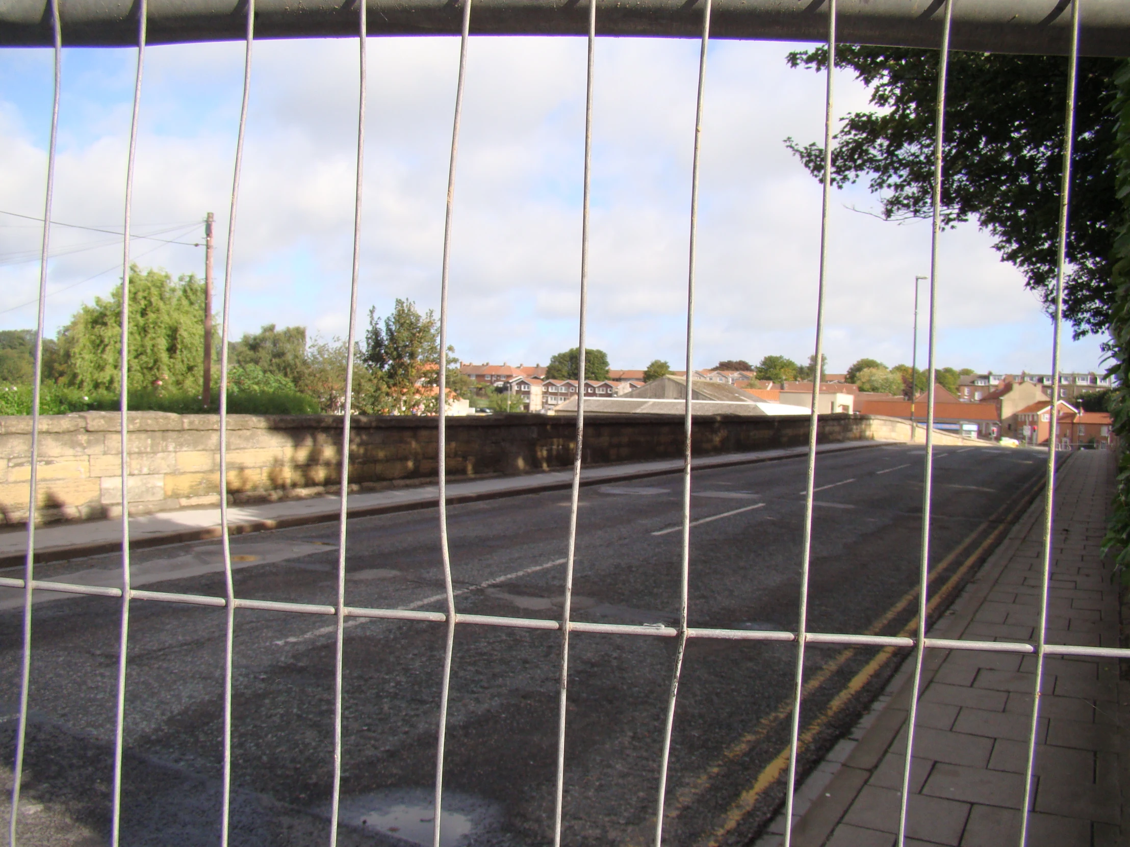 a view from a fence of the road in front of a fenced off area