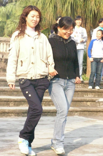 two woman are walking down some steps together