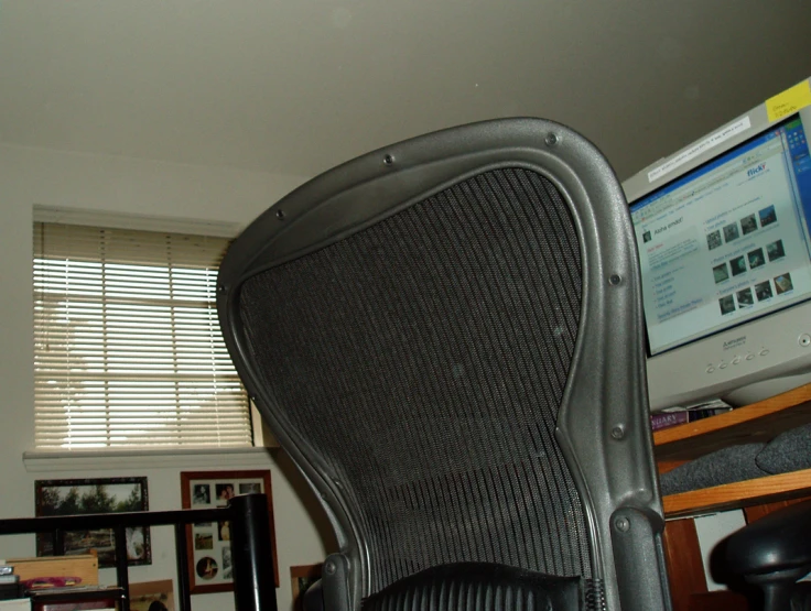 a large office chair sitting under a computer monitor