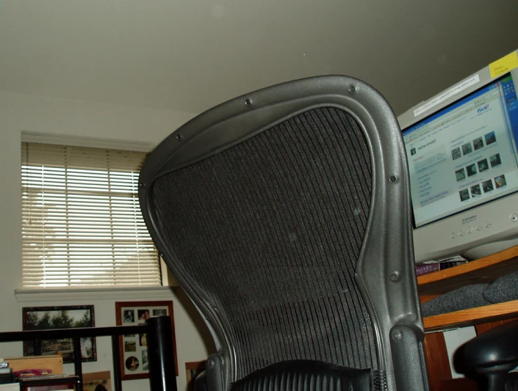 a large office chair sitting under a computer monitor