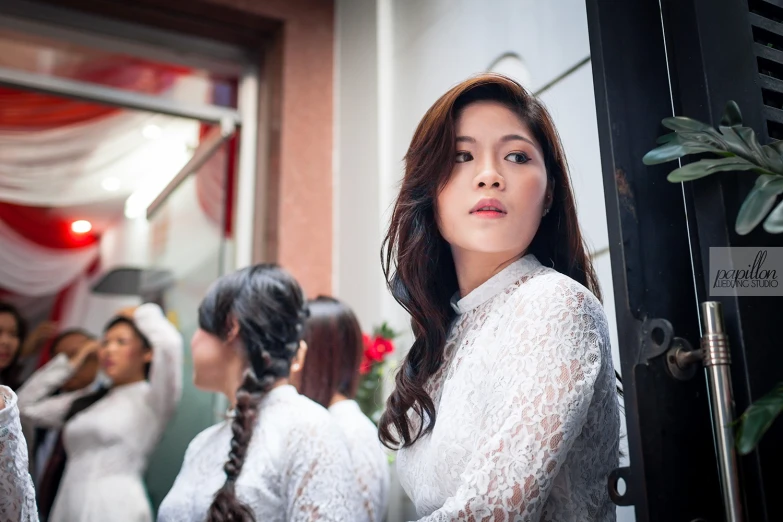 an asian woman in white with long black hair standing by some stairs