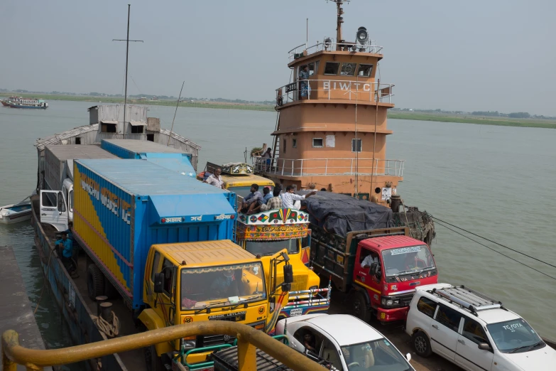 a small ferry is loaded with cargo near the shore