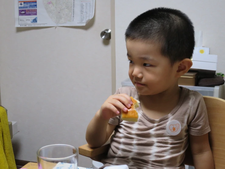 a child sits at the table eating food