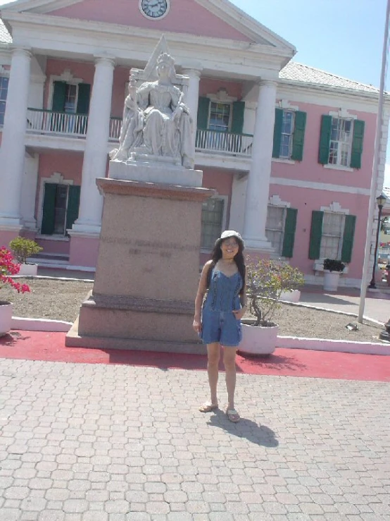 a woman is standing in front of a very large building