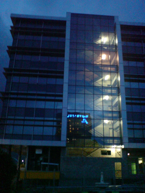 the large modern building at night has lots of lights