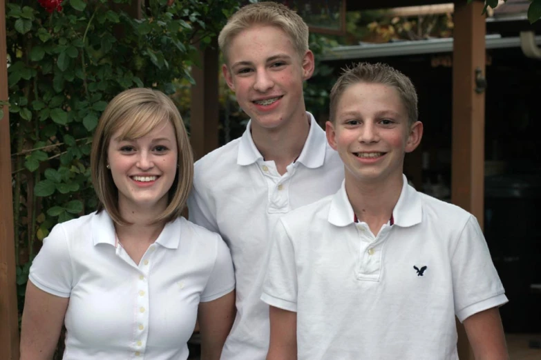 three people with white shirts posing for a po