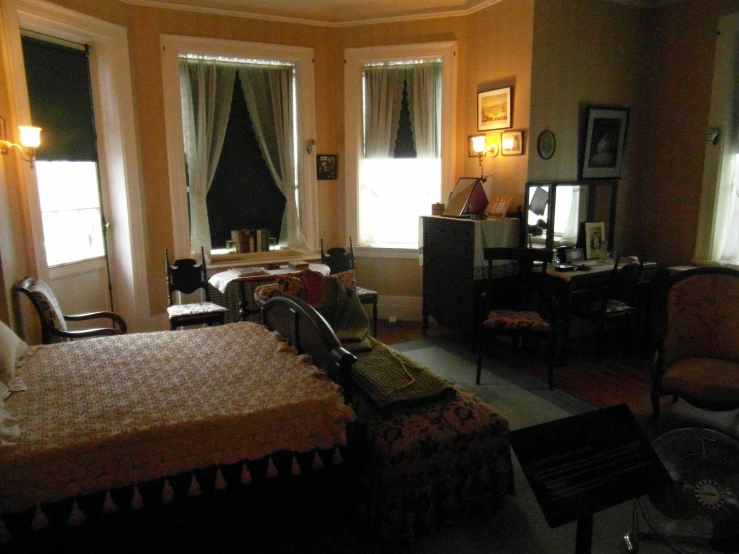 an elegant bedroom has two large windows and chairs