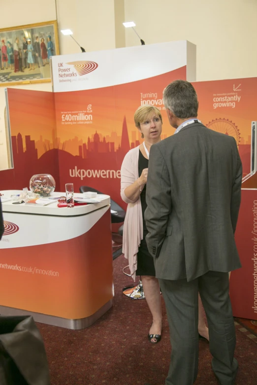 an image of a man and woman standing by booth