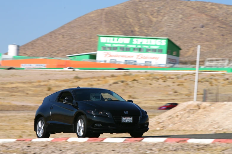 a car going down the highway with a building in the background