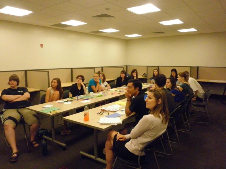 group of people sitting at a table listening to a lecture