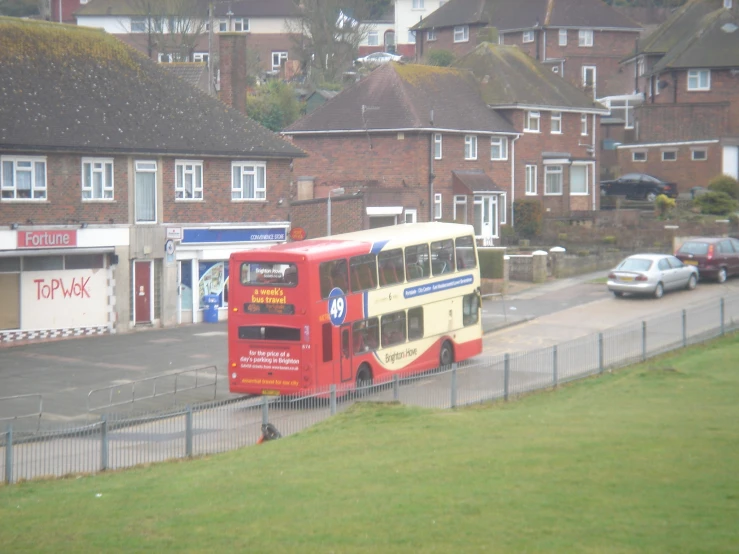 a big red city bus parked by a fence