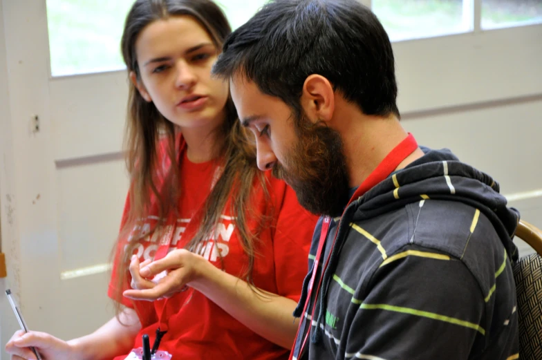 a man and woman looking at soing on the phone