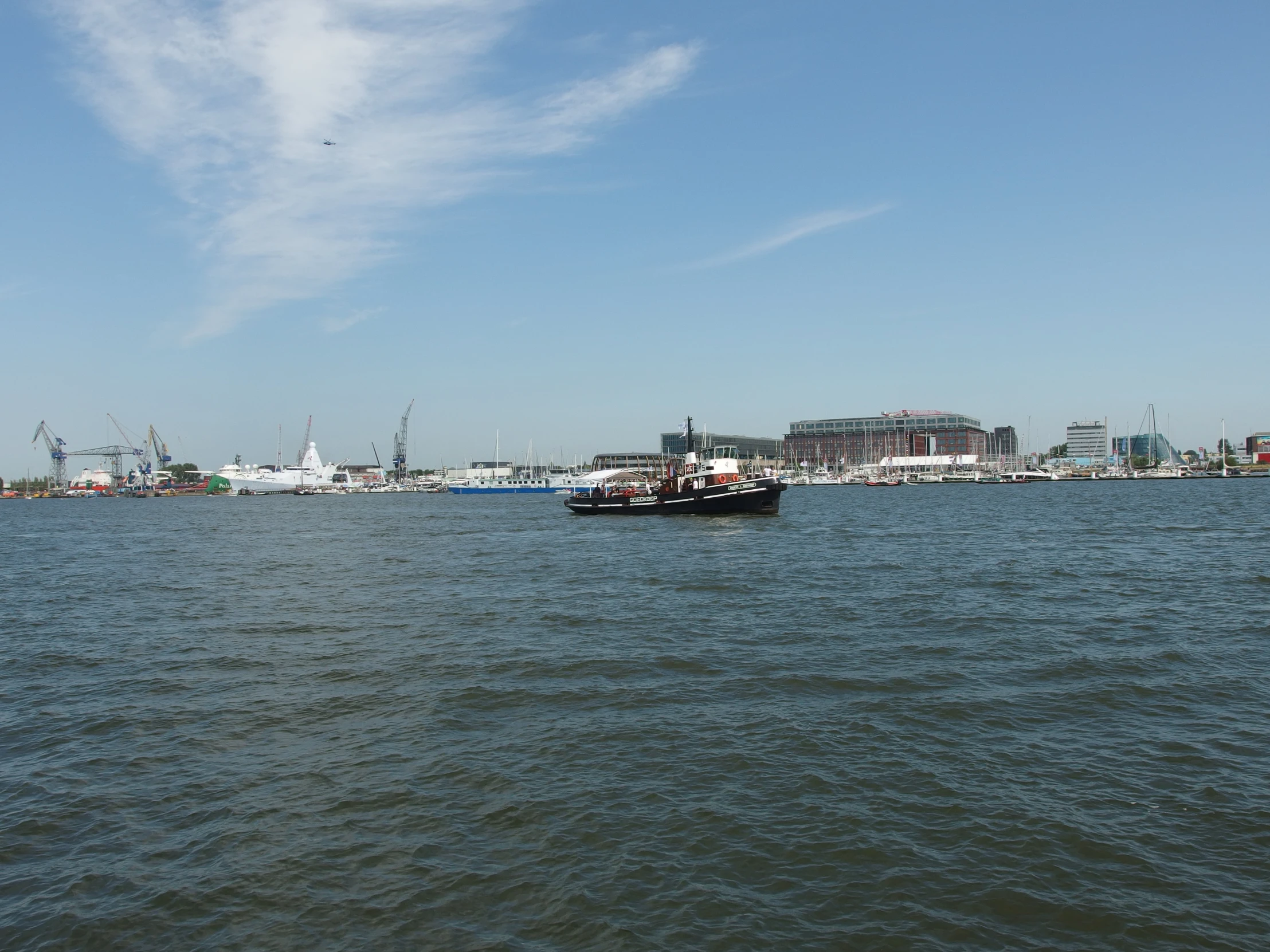 some boats that are in the water by some buildings