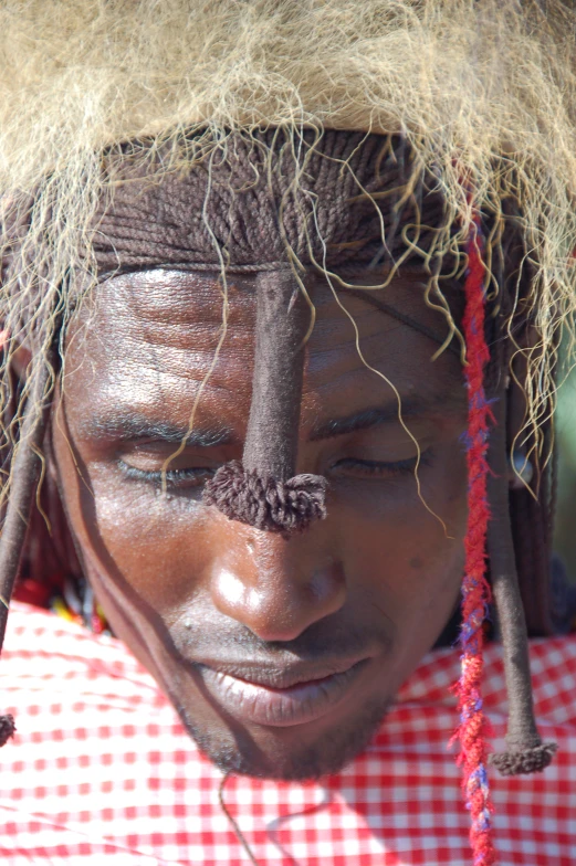 a man with two hair sticks is wearing a head piece