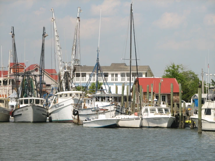 several white ships are docked near houses