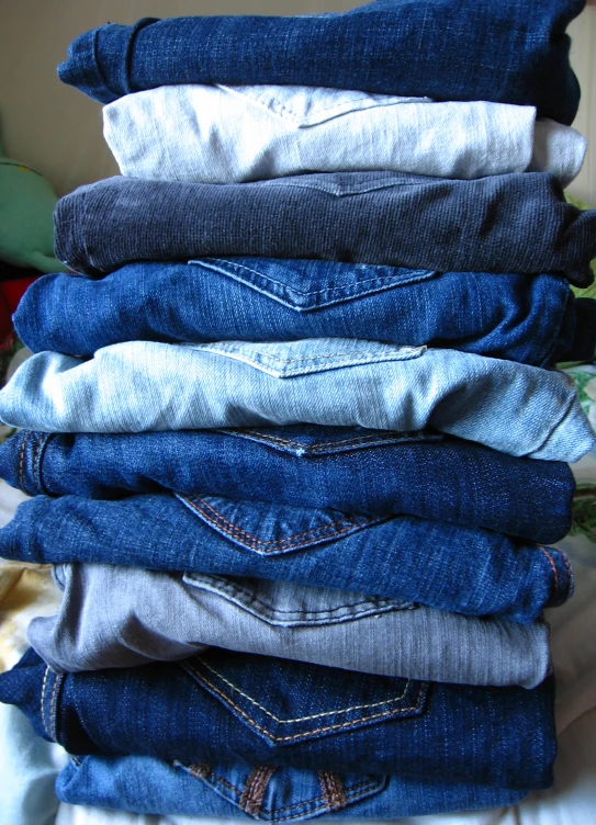 jeans piled in a stack on a table