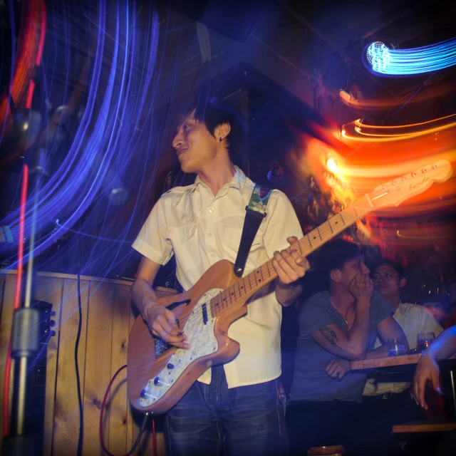 a man plays an electric guitar in a bar