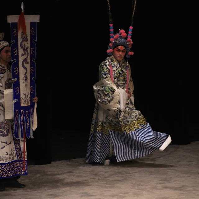 a male model walks on the catwalk with colorful asian accessories