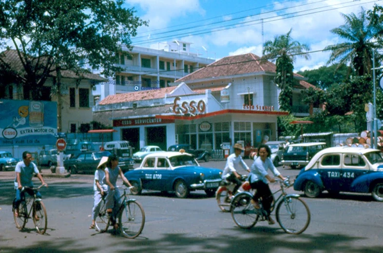 people are riding bicycles in front of a busy street