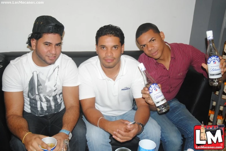 three young men with their drinks on a couch